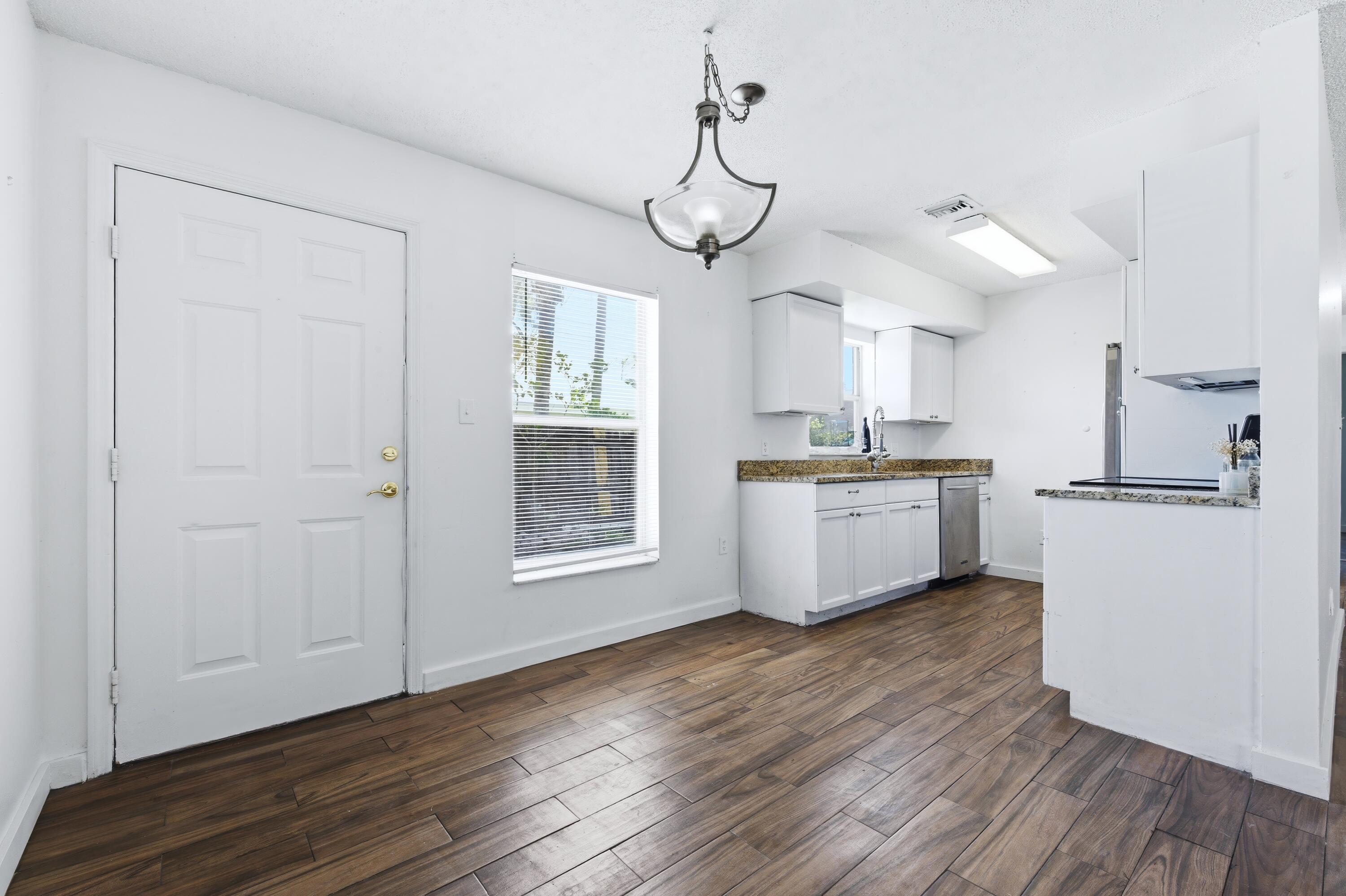 6088 Heather Street Jupiter, FL 33458 - Photo 6 of 18 a kitchen with a refrigerator a sink and cabinets