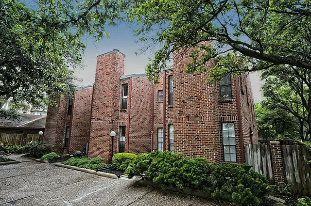 front view of a brick building next to a yard