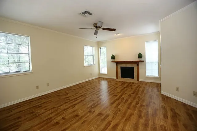 wooden floor fireplace and windows in an empty room