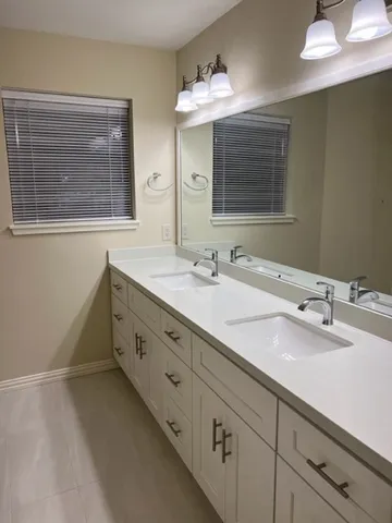 a bathroom with double sink and a mirror