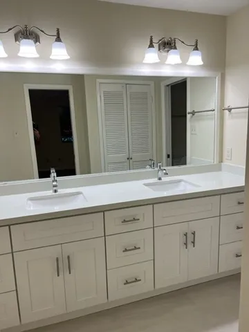 a bathroom with double sink and a mirror