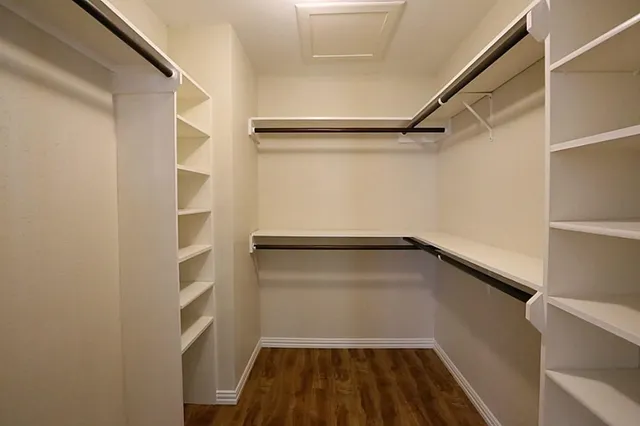a view of walk in closet with empty racks
