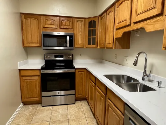a kitchen with stainless steel appliances a stove sink and microwave