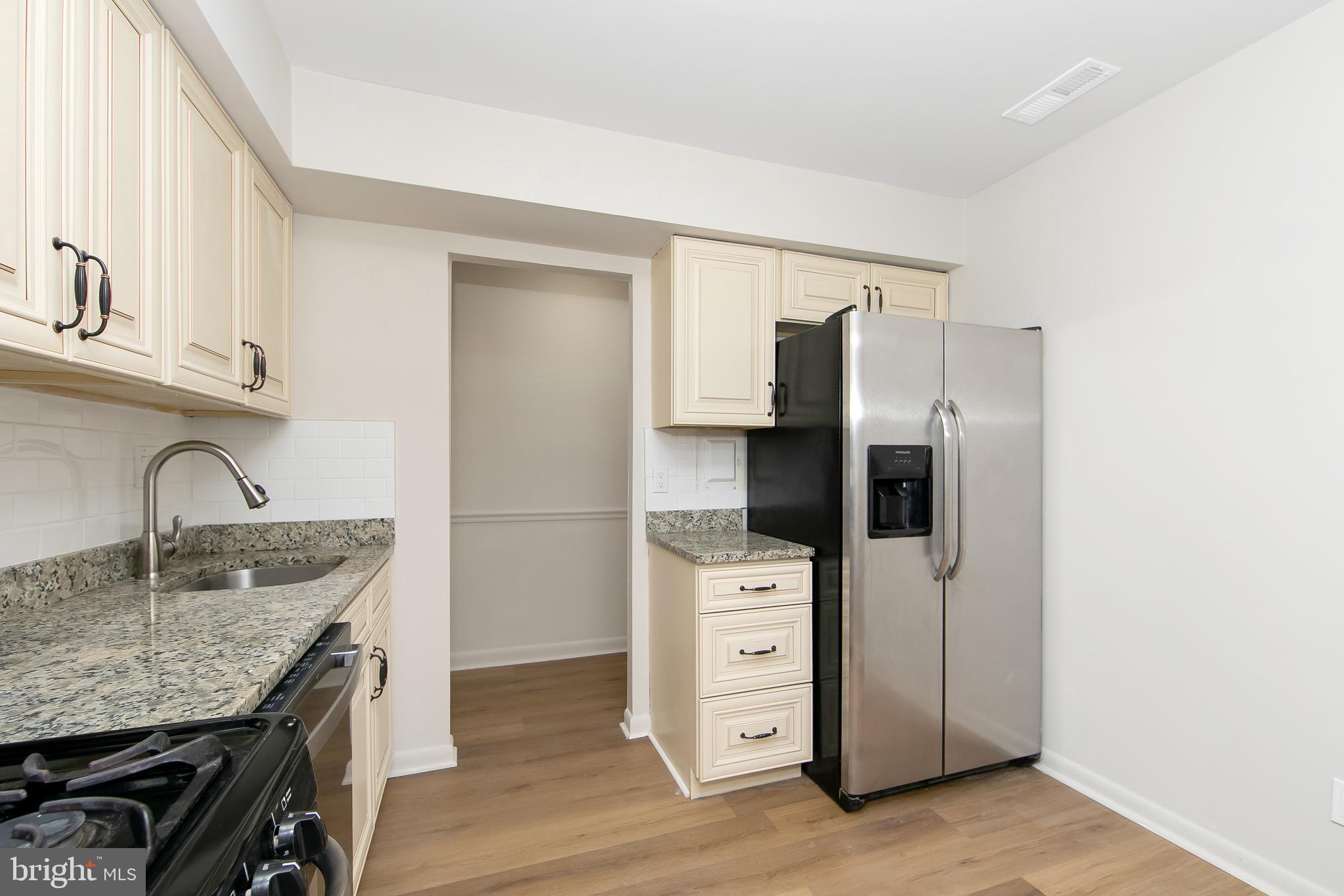 222 Echelon Road Voorhees, NJ 08043 - Photo 2 of 29 a kitchen with stainless steel appliances granite countertop a refrigerator a stove and a sink with wooden floors
