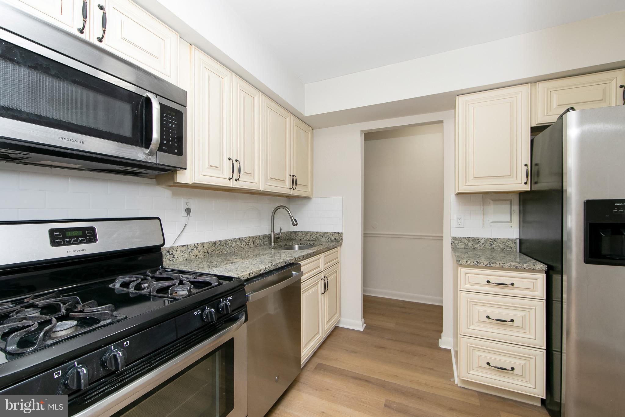 222 Echelon Road Voorhees, NJ 08043 - Photo 3 of 29 a kitchen with stainless steel appliances granite countertop a stove and a microwave