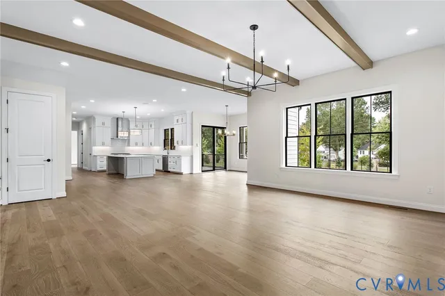 a large white kitchen with a large window appliances and cabinets
