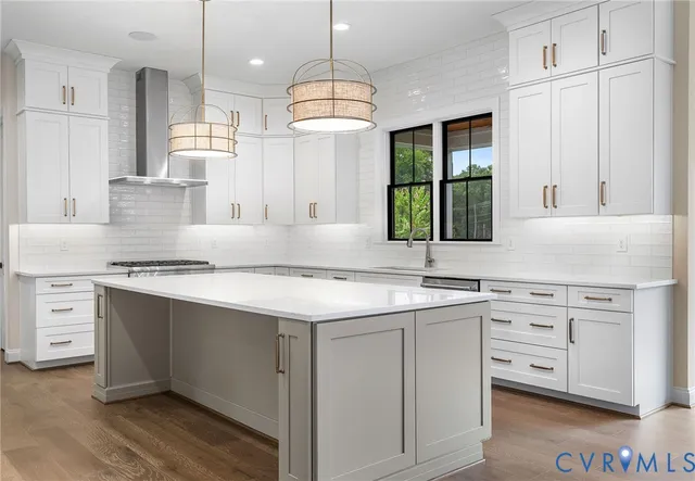 a kitchen with stainless steel appliances granite countertop a sink a stove and a wooden floors