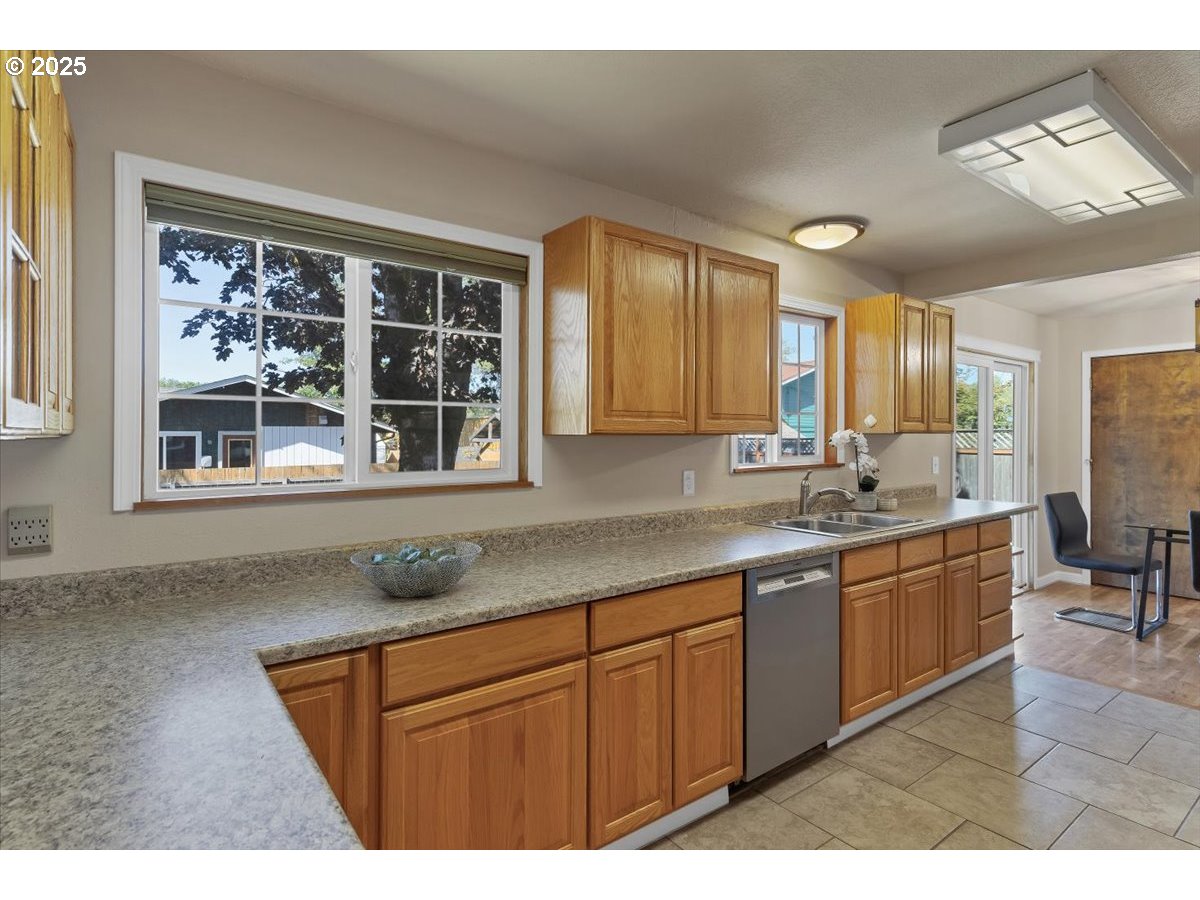 224 South 24th Street Philomath, OR 97370 - Photo 21 of 46 a kitchen with stainless steel appliances granite countertop a sink dishwasher a stove and a refrigerator with wooden floor