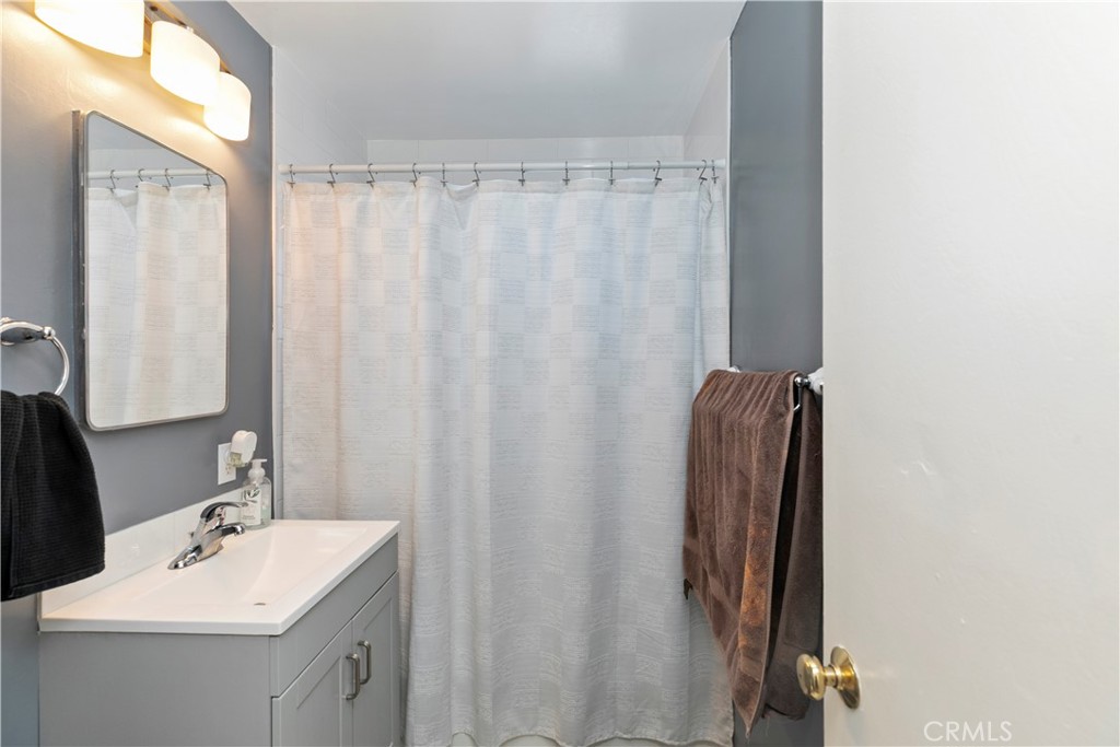 114 Juniper Street Brea, CA 92821 - Photo 15 of 64 a bathroom with a sink a mirror and a shower curtain