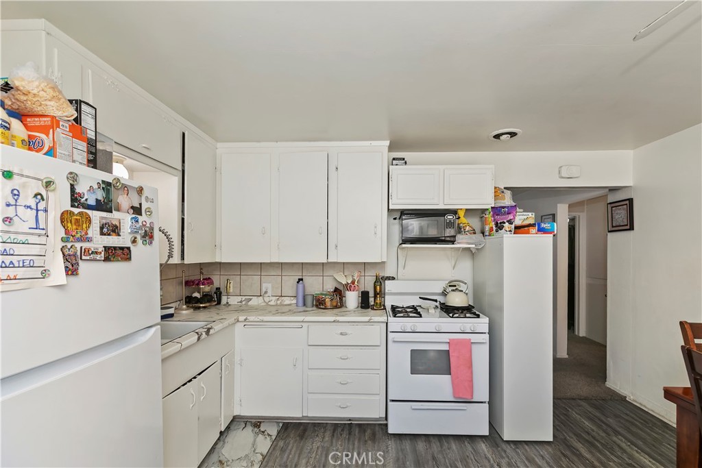 114 Juniper Street Brea, CA 92821 - Photo 53 of 64 a kitchen with stainless steel appliances white cabinets and refrigerator