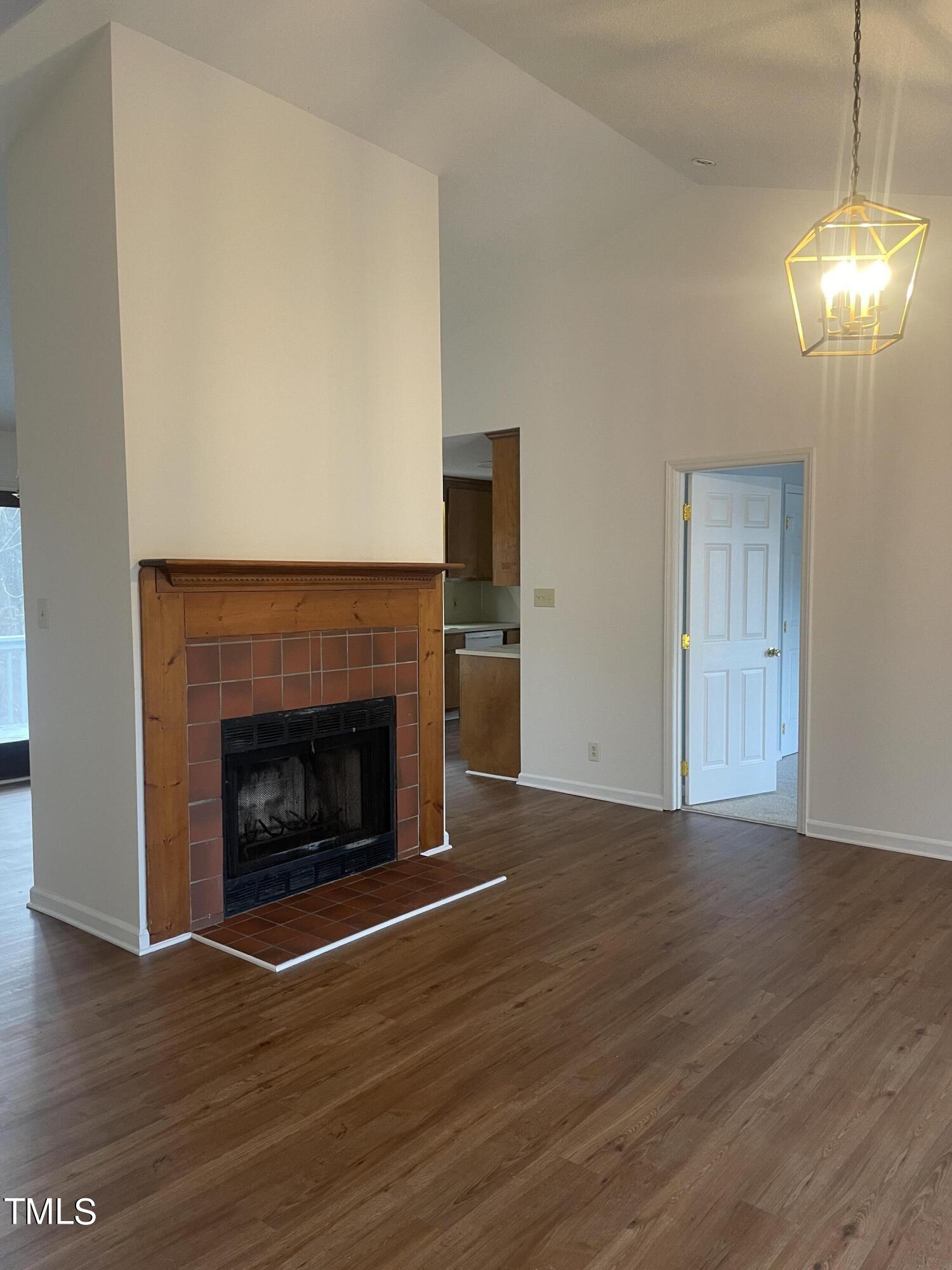 1015 Horton Road Durham, NC 27704 - Photo 3 of 15 a view of empty room with wooden floor and fireplace