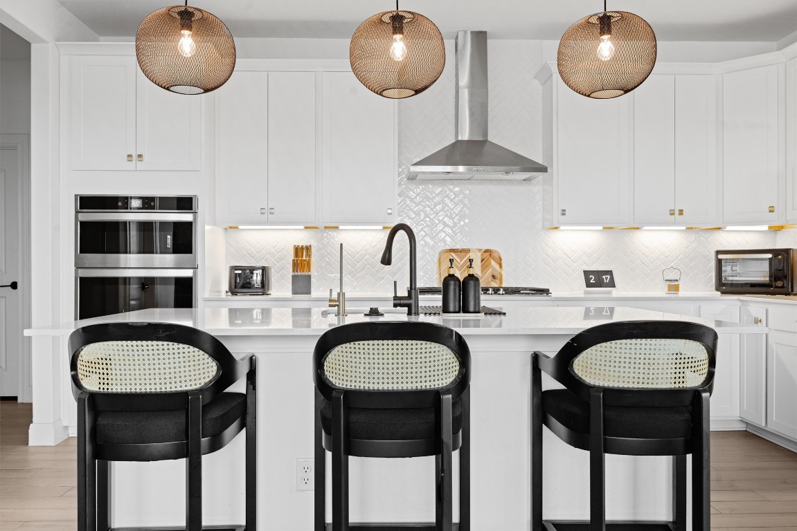 a kitchen with stainless steel appliances granite countertop a sink a stove a dining table and chairs