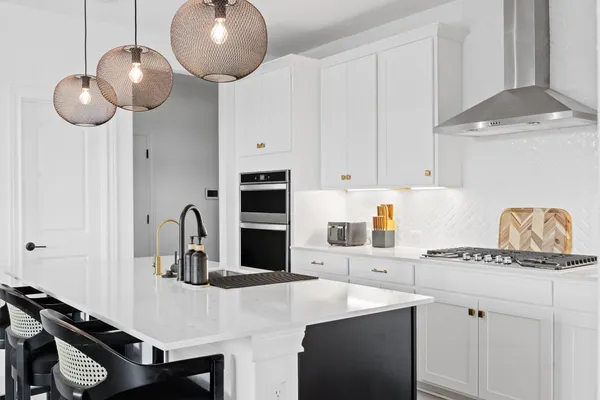 a kitchen with a refrigerator a stove and white cabinets