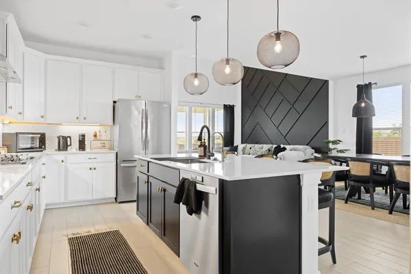 a kitchen with a sink stainless steel appliances a refrigerator and cabinets