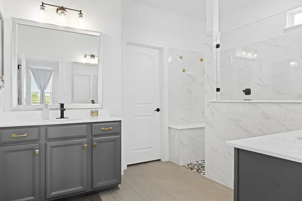 a spacious bathroom with a shower sink and mirror