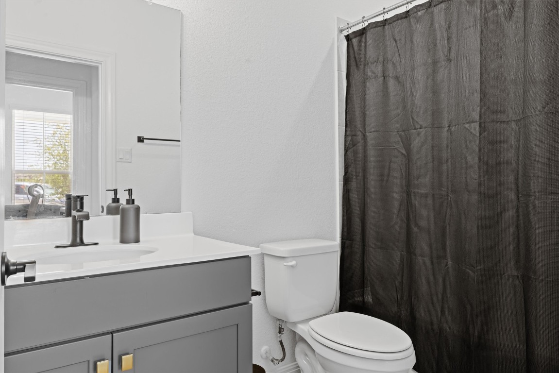 400 Turnbuckle Bend Leander, TX 78641 - Photo 25 of 40 a bathroom with a sink a toilet a mirror and shower curtain