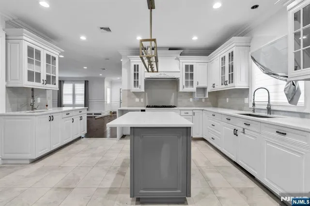 a kitchen with kitchen island a sink stainless steel appliances and cabinets
