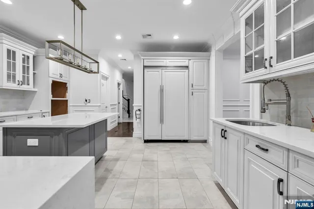 a large kitchen with kitchen island a sink a stove a refrigerator and a cabinets