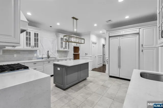 a kitchen with a sink a counter top space stainless steel appliances and cabinets