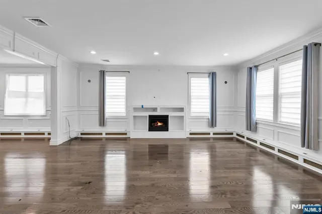 an empty room with wooden floor and fireplace