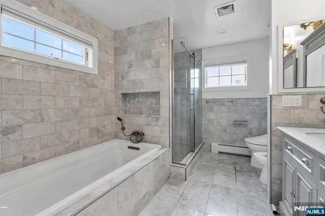 a bathroom with a granite countertop toilet a sink and bathtub