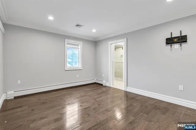 a view of an empty room with wooden floor