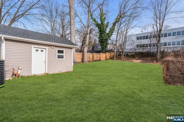 a view of a house with a big yard and large trees