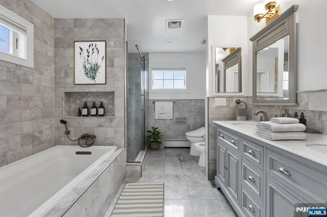 a bathroom with a tub a sink and a large mirror