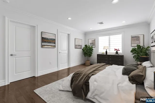 a bedroom with a bed and a potted plant on dresser