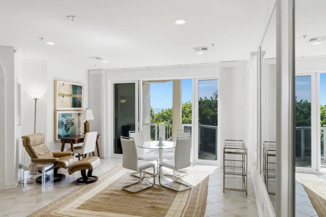 a living room with furniture large window and dining table