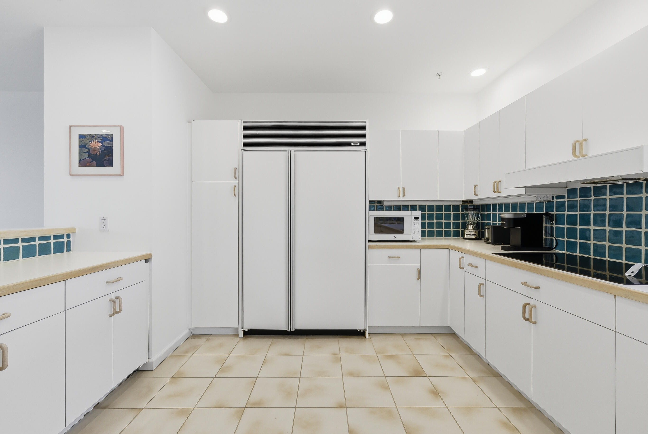 4535 Coquina Road Ocean Ridge, FL 33435 - Photo 19 of 45 a kitchen with white cabinets and white appliances
