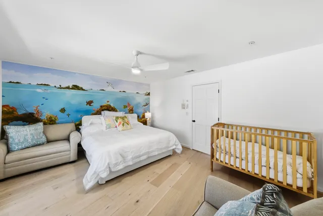 a bedroom with a bed and large windows