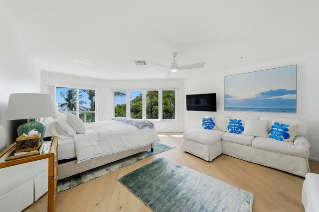 a bedroom with a bed and large windows