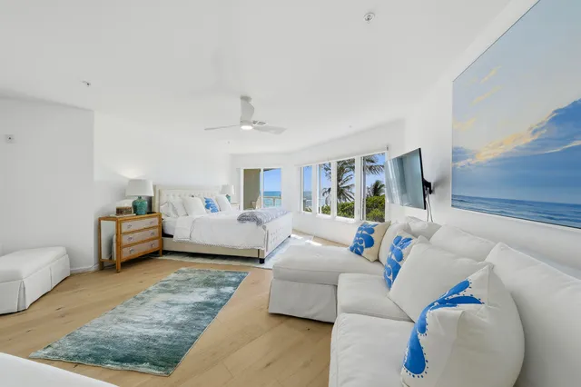 a spacious en suite bathroom with a granite countertop double vanity sink a bathtub and window