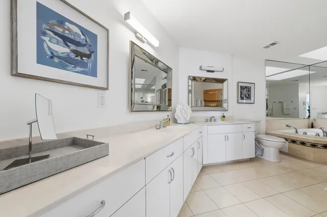 a spacious bathroom with a sink a large mirror and a bathtub