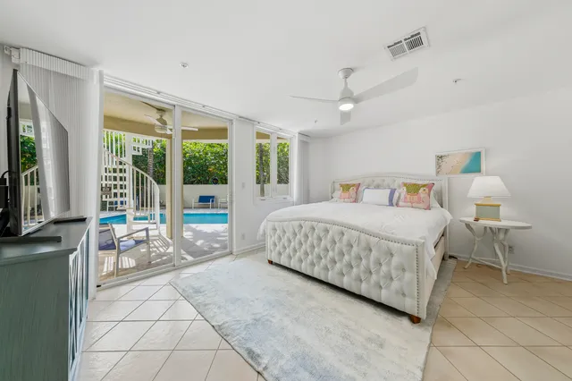 a bedroom with a bed and large windows