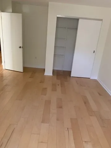 an empty room with a bench and cabinet