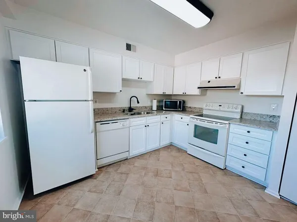 a kitchen with cabinets appliances a sink and a counter top