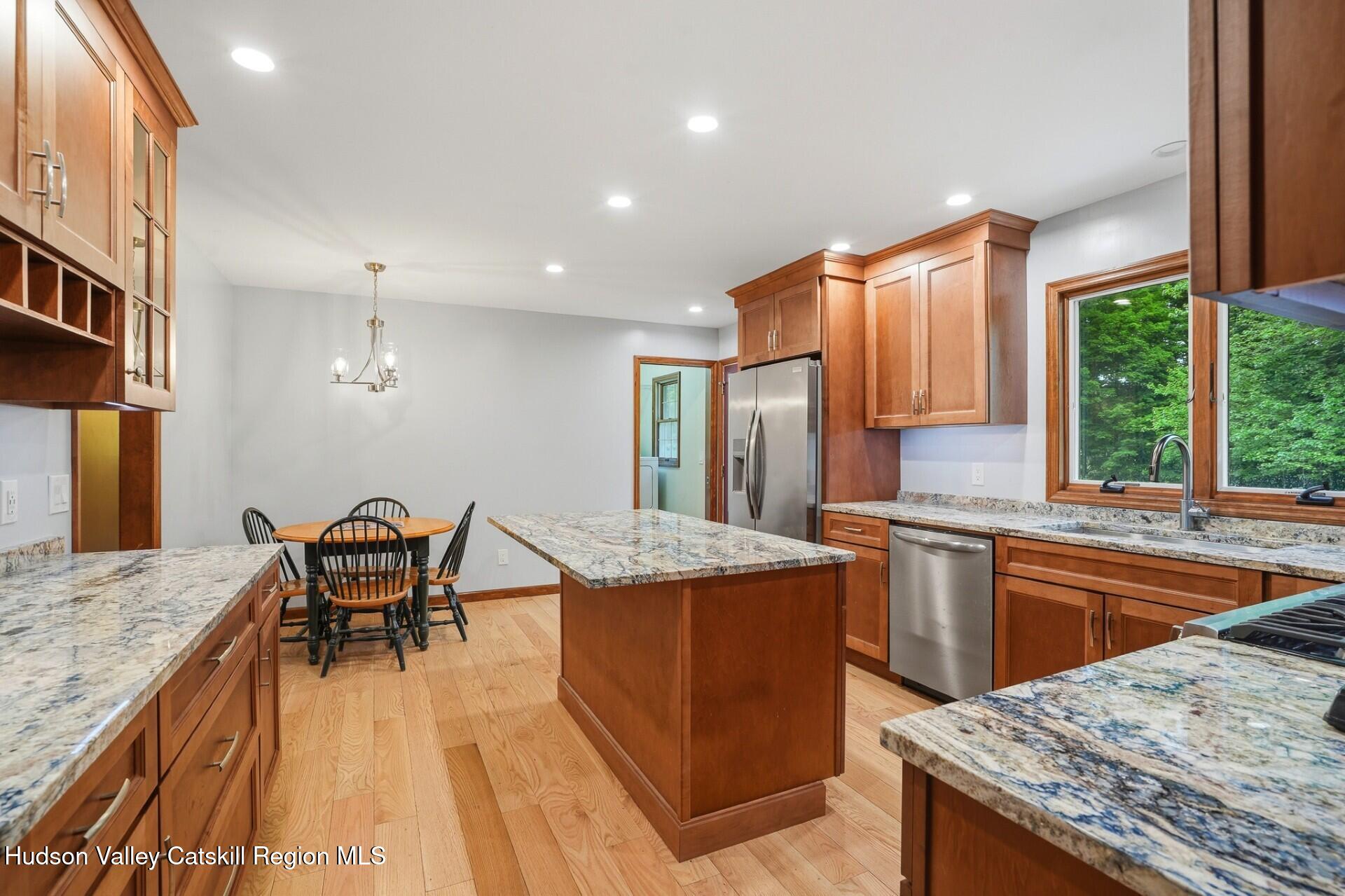 984 Blue Mountain Road Saugerties, NY 12477 - Photo 13 of 24 a open kitchen with stainless steel appliances granite countertop a stove top oven a sink dishwasher and chairs with wooden floor