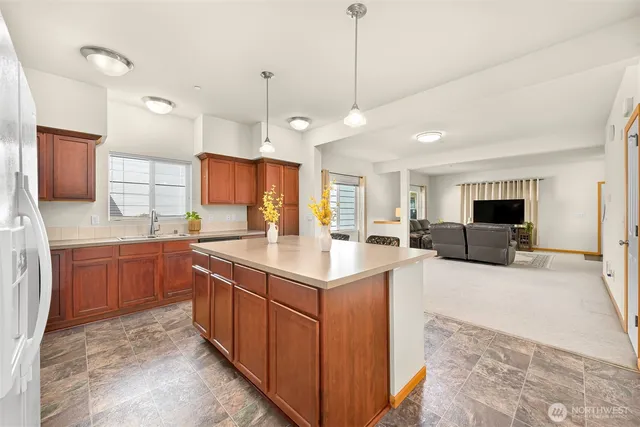 a large kitchen with kitchen island a sink appliances and a counter top space
