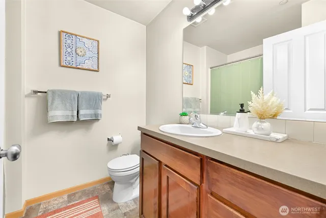 a bathroom with a granite countertop sink toilet and a mirror