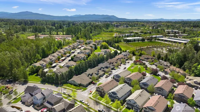 a view of a city with lots of residential buildings ocean and mountain view in back