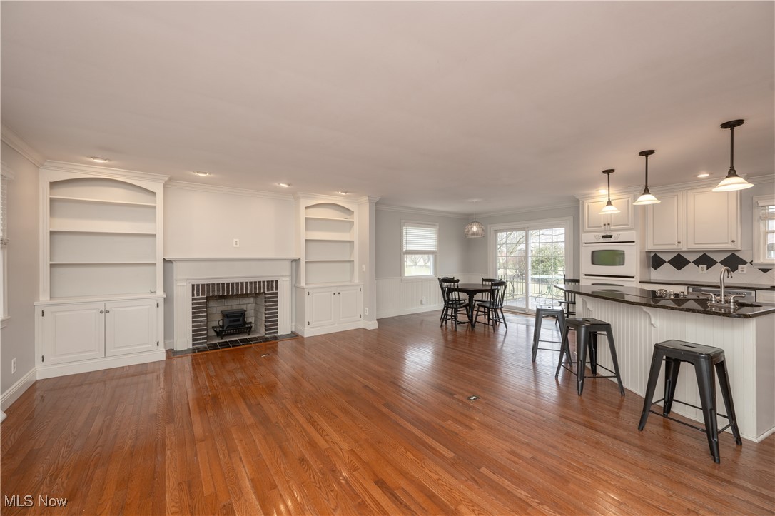 3721 20th Street Northwest Canton, OH 44708 - Photo 3 of 47 Living room with hardwood / wood-style floors, ornamental molding, and a brick fireplace