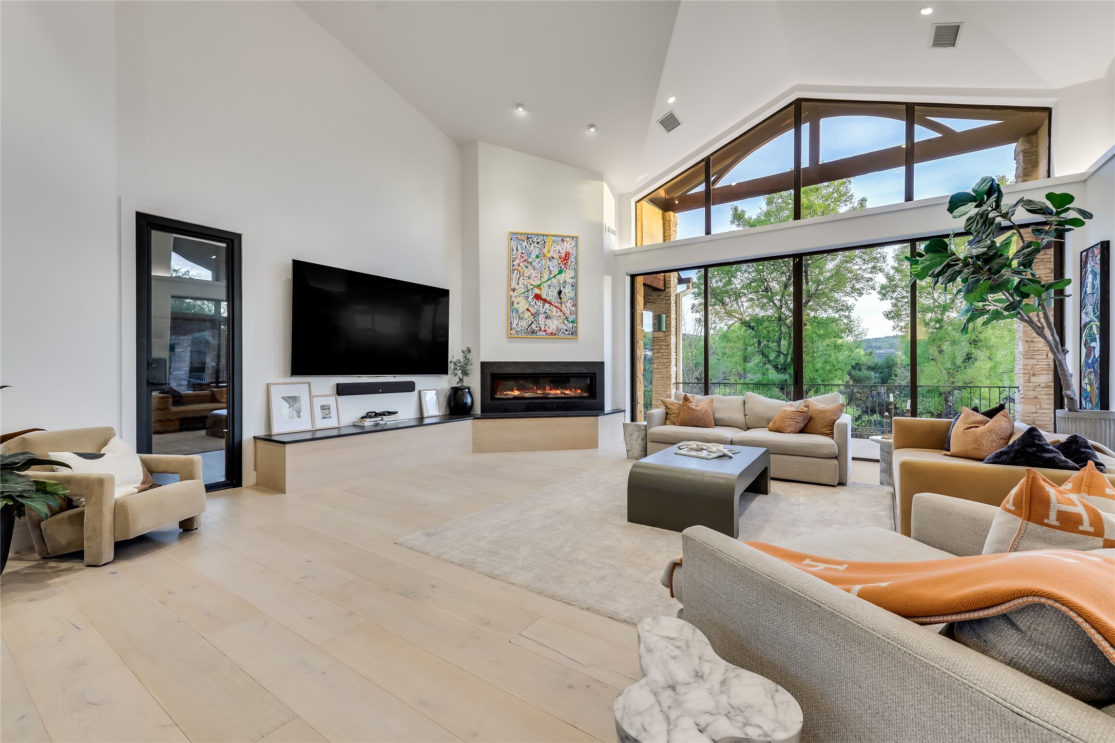 1016 Wild Basin Ledge Austin, TX 78746 - Photo 2 of 38 Living area with a fireplace, plenty of natural light, vaulted ceiling, wide wood plank flooring, and recessed lighting