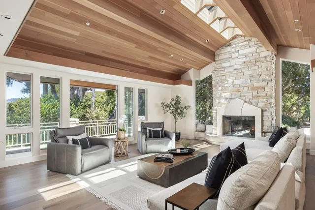 a living room with furniture a fireplace and a floor to ceiling window
