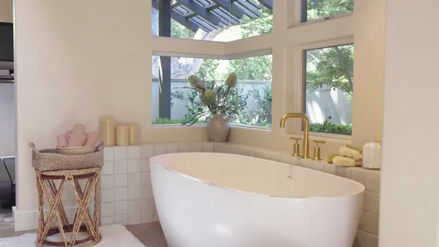 a white bath tub sitting in a bathroom next to a window
