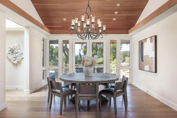 a view of a dining room with furniture a chandelier and wooden floor