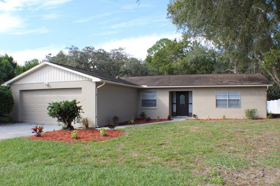 5067 Harbinger Road Spring Hill, FL 34608 - Photo 1 of 1 a view of a house with a yard and a large tree
