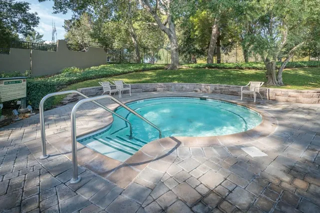 a view of a swimming pool with a patio and plants