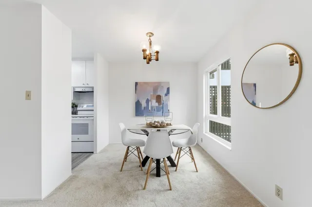 a view of a dining room with furniture and a mirror